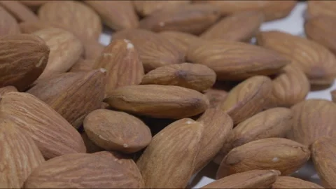 A close pan shot of dried almonds on a white table Stock Footage 280338692