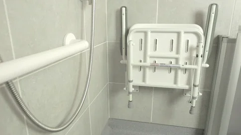 Close up pan shot of foldable disabled shower seat inside wet area bathroom Video stock 129794300