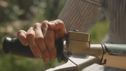 Close up pan shot of a man holding the handlebars of an old rusted classic Stock Footage 232451085