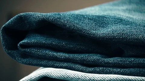 Close-up pan shot of the stack of dark and light blue pairs of jeans under .. Stock Footage 70567225