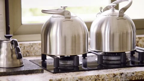 Close up pan of stove with tea pots and coffee pot 스톡 동영상 166986358