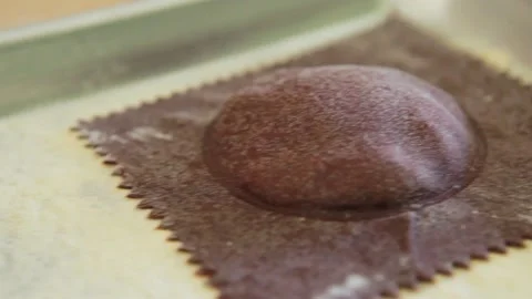 Close up pan of uncooked beet purple ravioli pasta on a sheet pan Stock Footage 199152053
