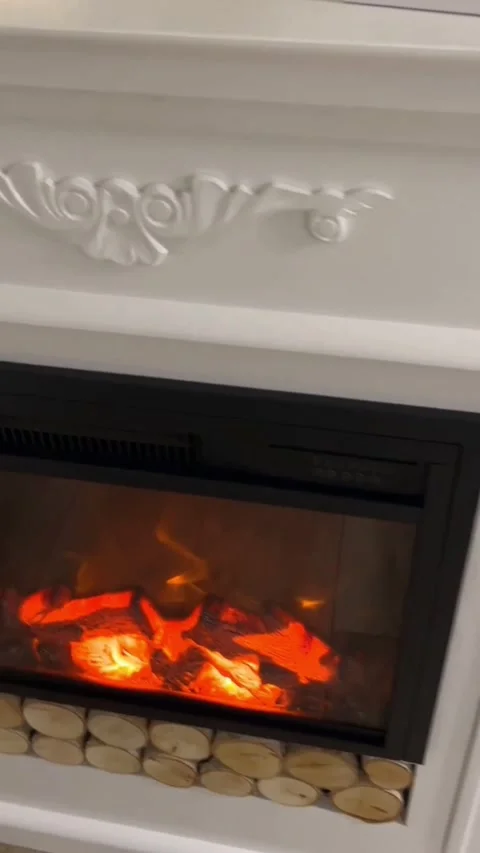 Close up pan of white handcrafted fireplace mantel with carved details and flame Stock Footage 341701188