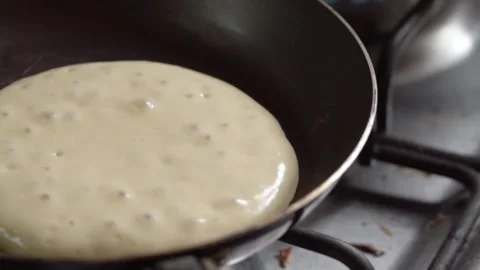 Close Up of Pancake Batter Cooking in Frying Pan on Gas Stove During Food Stock Footage 340798768