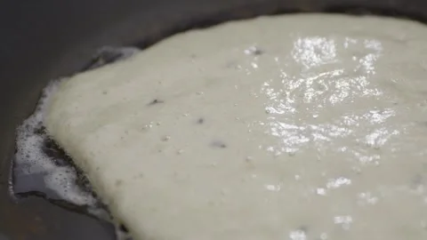 Close-Up of Pancake Cooking in Pan as Bubbles Form in Batter 動画素材 328963759