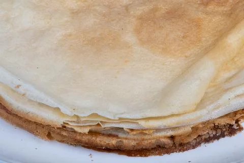 Close up pancakes stacked on plate, thin layered edges, goldenbrown surface,  Stock Photos