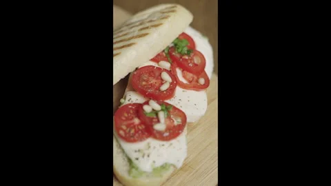 Close up of panini Caprese with mozzarella, tomatoes and basil pesto. Stock Footage 301926656