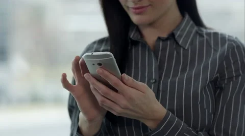 Up close pannig view of woman using smartphone by windows. Vídeo Stock 50501357