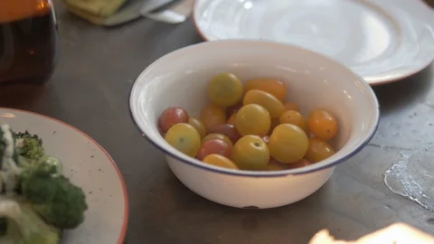 Close-up panning shot of broccoli and cherry tomatoes arranged on dining table Stock Footage 114842443