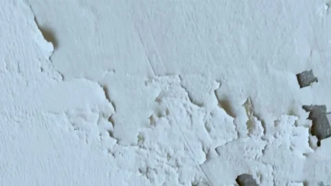 Close up panning shot of cracked white paint peeling off an old textured co.. Vidéo 337583824