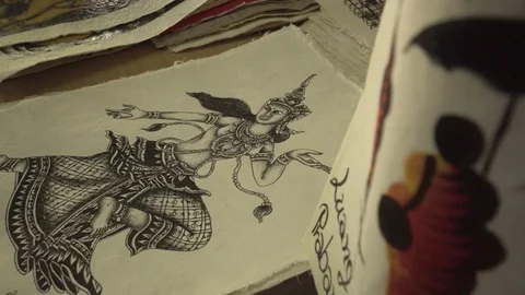 Close-up panning shot of drawings on papers for sale at store - Luang Phabang, Stock Footage 129212435