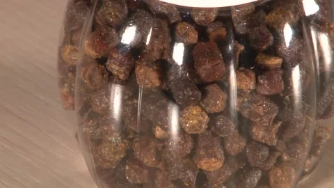 Close up panning of single plastic jar of perga with white cap on table Stock Footage 220651725