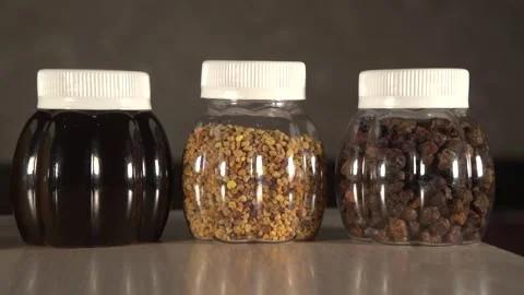 Close up panning to three plastic jars of some kinds honey, perga and pollen 動画素材 220482576
