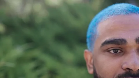 Close-up panning view of black man intense gaze with blue hair Stock Footage 287488785