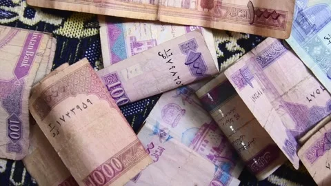 Close up panning view hundred and thousand Afghanis currency notes on bed i.. Stock Footage 279840207
