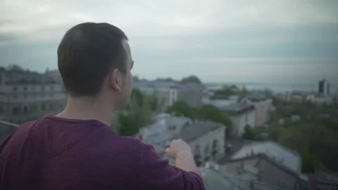 Close up panorama bird eye view on dark haired man standing on edge of roof dayd 動画素材 132675488