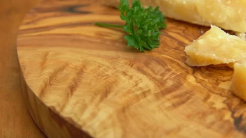 Close-up panorama of hard parmesan cheese pieces are laying on the wooden board Stock Footage 136695009