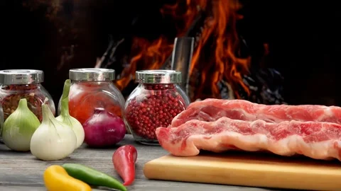 Close-up panorama of the raw ribs on the board on the background of an open fire Stock Footage 280482006