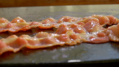 Close-up panorama of strips of bacon roasting of the flat grill surface Stock Footage 136695722