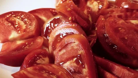 Close-up panoramic shoot of the tomatoes sliced into pieces on a white plate. HD 库存影片 70933734