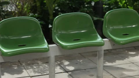 Close up panoramic shot of empty green plastic seats on city street sidewalk bus Vidéo 310223053