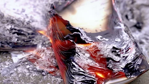Close-up of paper pages burning with orange flames Video stock 329863772