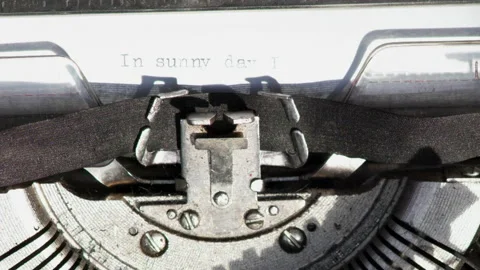 Close up of paper with typed text IN SUNNY DAY I being pulled out of typewriter Stock Footage 185373551