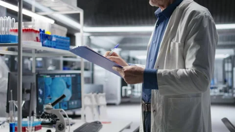Close up of papers used to check on chemical data during lab work Stock Footage 317786071