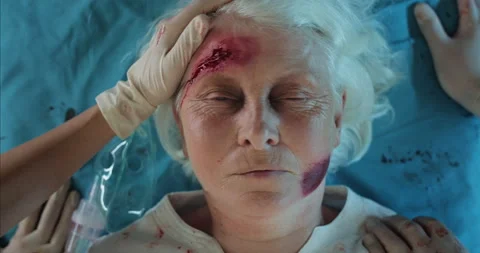 Close up of paramedic checking heart beat to old woman with wounds and blood on Stock Footage 142364528