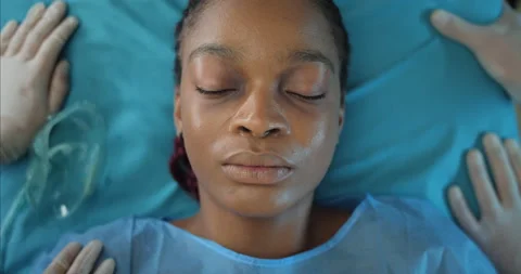 Close up of paramedics putting on ill afro american girl face oxygen inhalation Stock Footage 137253496
