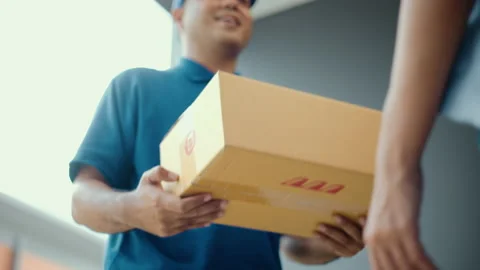 Close up parcel in hand of blue uniform delivery man to customer. Stock Footage 195388922