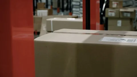 Close-up of parcels in a warehouse with cardboard box moving along the packaging 스톡 동영상 128294869