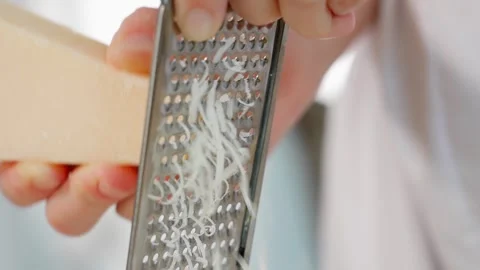 Close-up of Parmesan cheese being grated on a fine grater Stock Footage 266317726