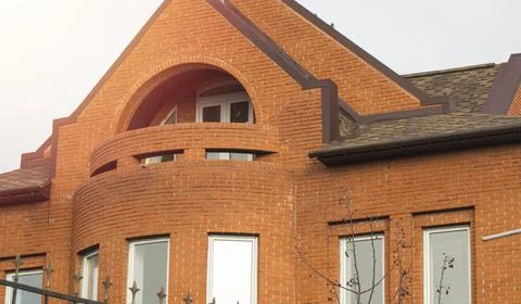Close-up of a part of the facade of a red brick cottage house with windows an Foto stock