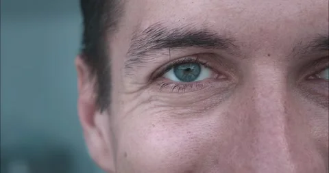 Close-up part face of smiling man with dazzling green eyes. Man gaze radiates Stock Footage 264743314