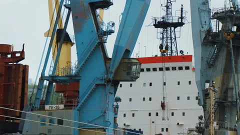 Close-up of the part of a large merchant ship and part of a cargo port cranes Stock Footage 92204866