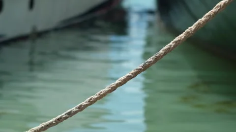 Close up of part of moored passenger ship. bow of ship with rope near shore with Stock Footage 280229644