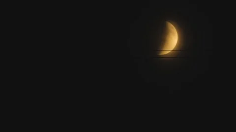 A close-up of a partial lunar eclipse. The crescent moon shines softly against Stock Footage 317514638