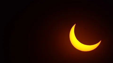 Close up of partial solar eclipse while sun is moving on the sky. Crane in fr Stock Footage 122129858