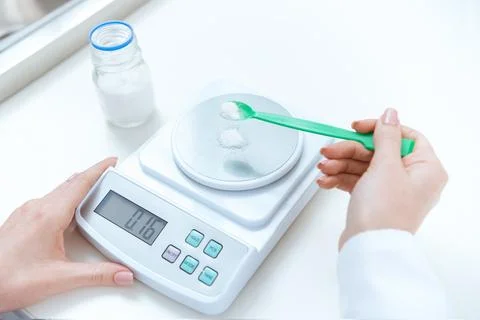 Close-up partial view of chemist weighing reagent on laboratory scales Stock Photos