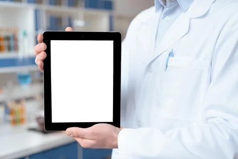 Close-up partial view of doctor in lab coat showing digital tablet with bla.. Stock Photos