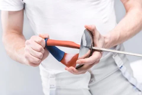 Close-up partial view of young man professional fencer holding rapier Stock Photos