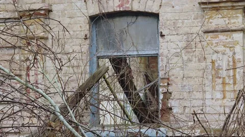 Close up of partially boarded up windows of abandoned brick house Video stock 220592887