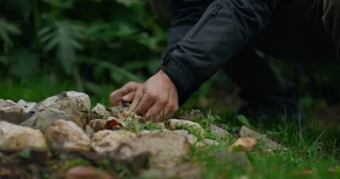 Close-up of participant building stone altar for Shamanic Fire surroundings Stock Footage 325367734