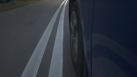 Close-up of a passenger car tire driving on a wet, slippery autumn road surface Stock Footage 287976455