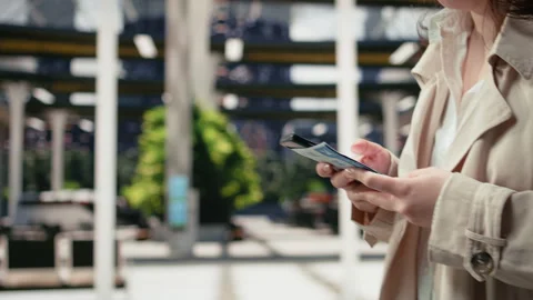 Close up of passenger typing text messages on mobile device inside coach station Stock Footage 340199621