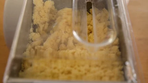 Close-up of a pasta dough mixing machine with semolina dough being mixed inside. Stock Footage 95769348