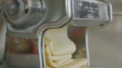 Close up of pasta machine making dough rolling layers Stock Footage 256979467