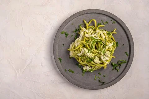Close up pasta with pesto, stracciatella cheese and parsley served on gray Stock Photos