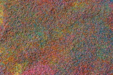 Close up of pastel coloured sand splashed red  background. Stock Photos
